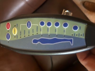 Handheld remote control for a massage chair or mattress pad, featuring heat, intensity, and zone-specific settings.