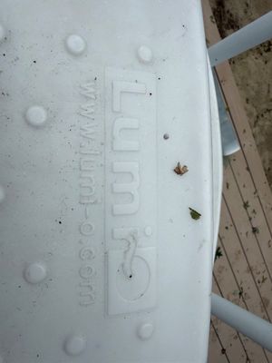 Lumi-O white plastic pool steps with textured tread, showing some outdoor wear.