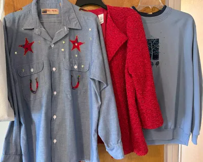Vintage Big Mac chambray work shirt with custom western-themed star and horseshoe appliques, shown hanging alongside a red textured...
