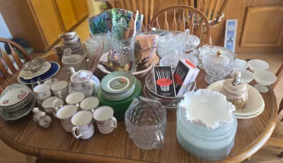 Assorted vintage glassware and tableware collection, including patterned teacups, saucers, a floral teapot, cut glass bowls, and milk...