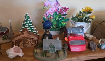Assortment of vintage collectibles and decor, including a red View-Master, a miniature ceramic Christmas tree, a small blue glass oil...