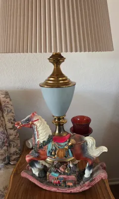 Vintage table lamp featuring a light blue and brass urn-style base with a pleated beige shade, displayed alongside a decorative rocking...
