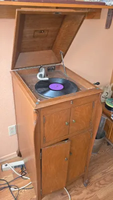 Antique Victor Victrola VV-X floor model phonograph in a golden oak cabinet, featuring a hand-crank mechanism and lower record storage...