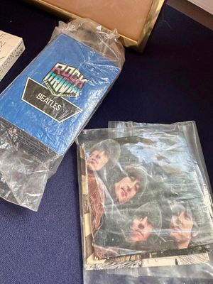 Vintage Rock Trivia Beatles card game deck and a Rubber Soul era Beatles picture booklet, both sealed in protective plastic sleeves.
