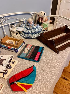 Assortment of vintage items including a Cabbage Patch doll, a crochet-skirted doll, a wooden book trough, a circular slide rule manual,...
