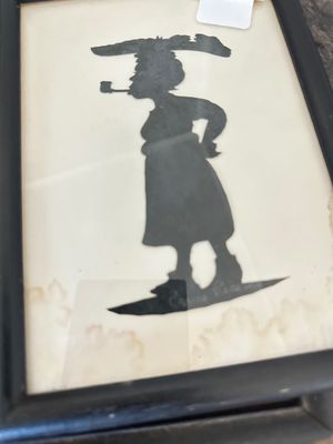 Carew Rice Vintage framed silhouette art depicting a woman smoking a pipe while carrying a load on her head, showing some water damage...