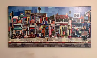 Large panoramic canvas print featuring a colorful, stylized collage of urban storefronts and buildings.