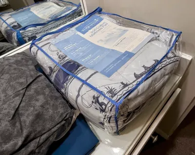 Therapedic 250 cotton thread count mattress pad, packaged in its original zippered plastic storage bag.