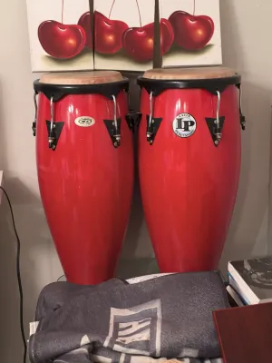 Pair of Latin Percussion (LP) conga drums in a vibrant red finish, featuring black hardware and natural rawhide heads.