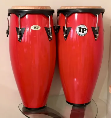 Pair of Latin Percussion (LP) conga drums in a vibrant red finish, featuring black hardware and natural rawhide heads.