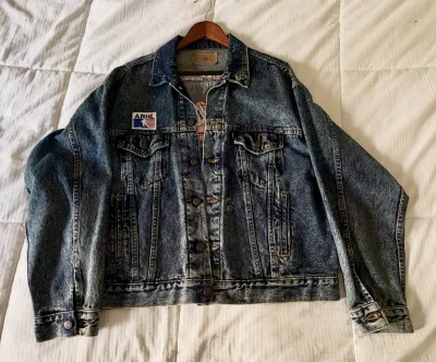 Vintage Levi's acid-wash denim jacket featuring an ARHL patch on the chest, displayed on a wooden hanger.