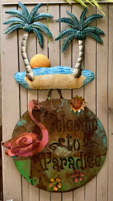 Rustic metal tropical welcome sign featuring a pink flamingo, palm trees, and the text "Welcome to Paradise" with a weathered,...