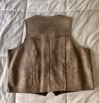 Vintage brown leather or suede vest with a western-style yoke back, showing some wear and natural patina.