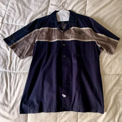 Harley-Davidson short-sleeve button-up shirt in navy blue and tan, featuring embroidered logo details and chest pockets.