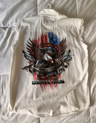 White sleeveless denim shirt featuring a graphic for the 2017 Leesburg Bike Fest, complete with an eagle, American flag, and motorcycle...