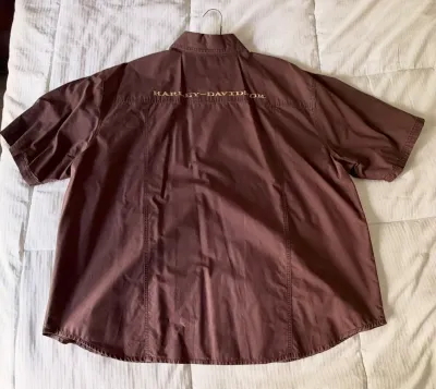Brown short-sleeve Harley-Davidson button-up shirt with embroidered branding across the upper back.