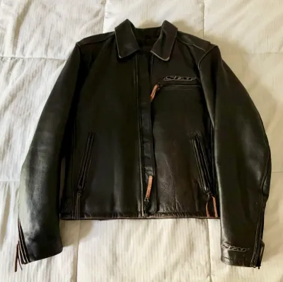 Star Motorcycles black leather riding jacket featuring zippered pockets, zippered cuffs, and leather pull tabs.