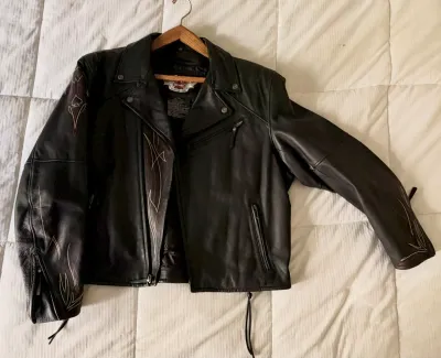 Harley-Davidson black leather motorcycle jacket featuring embroidered flame and spade details on the sleeves and lapel, complete with...