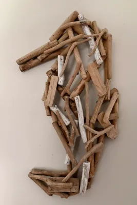 Coastal-style driftwood wall sculpture in the shape of a seahorse, featuring natural and whitewashed wood pieces.