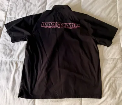 Black Harley-Davidson short-sleeve button-down shirt featuring pink embroidered branding and the slogan "On this road, we all ride...