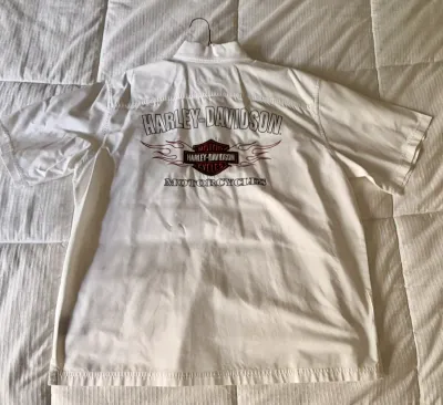 White Harley-Davidson short-sleeve button-up shirt featuring an embroidered bar and shield logo with flames on the back.
