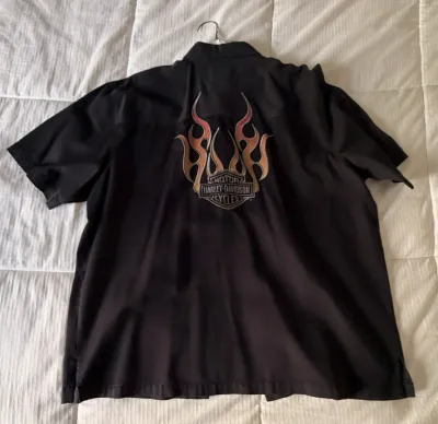 Black short-sleeve Harley-Davidson button-up shirt featuring a flame graphic and the classic bar and shield logo on the back.