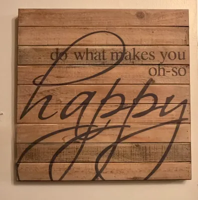 Rustic wooden slat wall sign featuring the printed quote "do what makes you oh-so happy" in a mix of serif and script fonts.