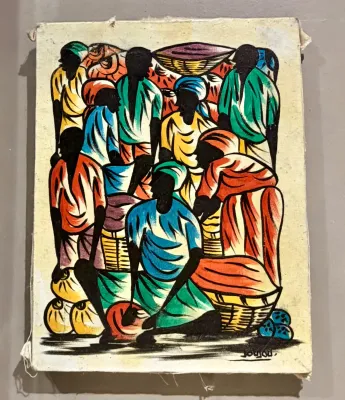 Haitian market scene painting on canvas, featuring stylized figures in vibrant clothing, signed 'Jousou' at the bottom right.