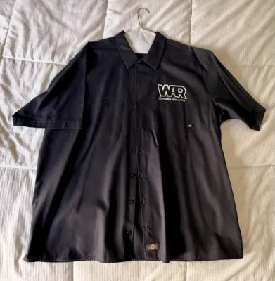 Black Dickies short-sleeve work shirt featuring a white embroidered "WAR Lowriding Since 1969" logo on the left chest.