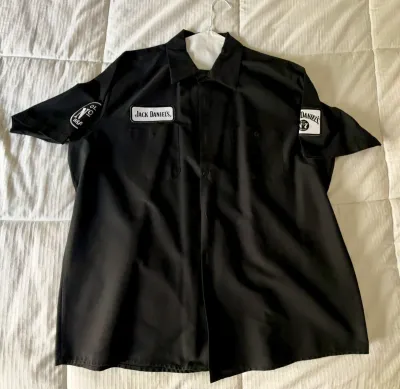 Black Jack Daniel's short-sleeve work shirt featuring embroidered brand patches on the chest and sleeves.