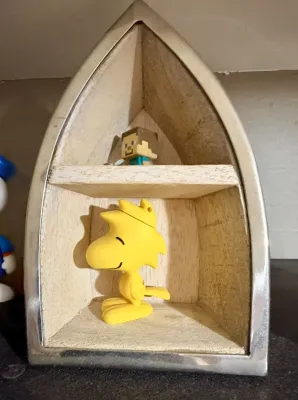 Small wooden shadow box shaped like a boat bow with a silver metal frame, displaying a yellow Woodstock figurine and a Minecraft Steve...