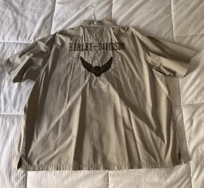 Harley-Davidson short-sleeve button-up shirt in tan, featuring embroidered back graphics with a winged skull motif.