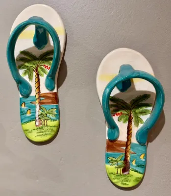 Pair of hand-painted ceramic flip-flop wall decorations featuring tropical beach scenes with palm trees and sailboats.