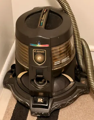 Rainbow e Series water filtration vacuum cleaner with hose, showing some wear from use.
