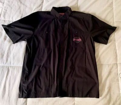 Black short-sleeve button-up Harley-Davidson shirt featuring a pink embroidered logo on the left chest pocket.