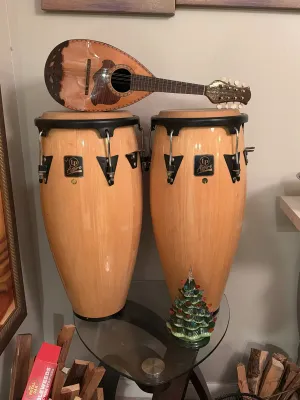 Pair of LP Aspire wood conga drums with natural finish, topped with a vintage bowl-back mandolin featuring decorative wood inlays.