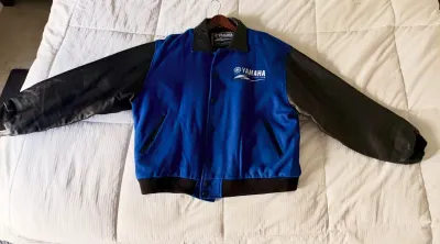 Yamaha Factory Racing varsity-style jacket featuring a blue wool body, black leather sleeves and collar, and embroidered chest logo.