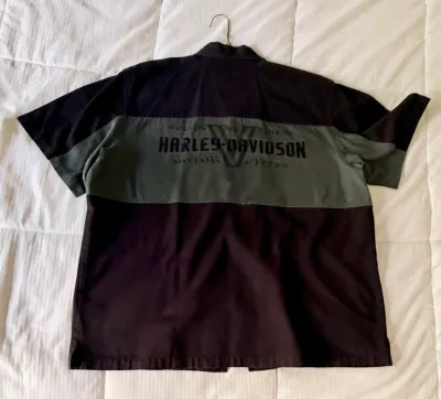 Harley-Davidson short-sleeve button-up shirt featuring a black and olive green color-blocked design with embroidered branding on the back.