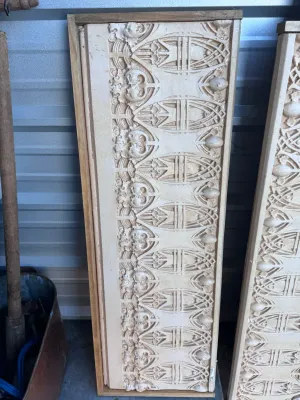 Sale Photo Thumbnail #29: A pair of decorative wall panels featuring highly detailed Gothic Revival style plaster relief friezes. The panels showcase intricate tracery, foliate motifs, and architectural elements finished in an off-white/cream tone. Each plaster section is mounted 