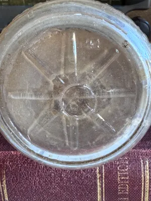 Sale Photo Thumbnail #307: A vintage clear glass one-pint milk bottle featuring embossed lettering. One side reads 'Universal Store Bottle / Sealed 1-11-14 / One Pint Liquid / Reg. U.S. Pat. Off.' and features vertical ribbing. The reverse side is embossed with 'Store Bottle' and a
