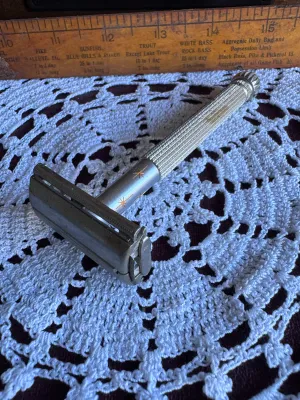 Sale Photo Thumbnail #251: Vintage Lady Gillette double edge safety razor featuring a textured silver-tone handle with the iconic gold-tone starburst design on the collar. Made in the USA by Gillette. This classic twist-to-open (TTO) butterfly razor is in good vintage condition wit