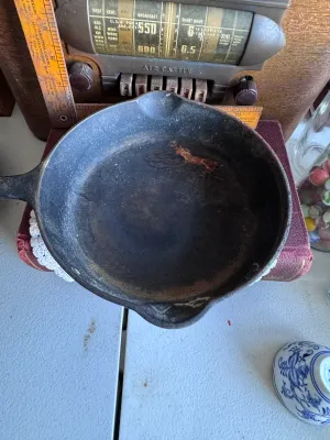 Sale Photo Thumbnail #266: An authentic vintage Griswold No. 5 cast iron skillet, model number 724 G. Made in Erie, Pennsylvania, USA. Features the classic Griswold small logo marking on the bottom. The skillet shows signs of age and use, including surface wear, some build-up, and 