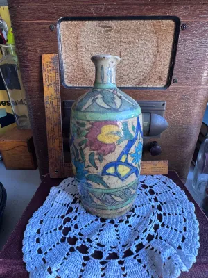 Sale Photo Thumbnail #72: An antique hand-painted earthenware pottery vase or bottle, featuring traditional floral and foliate motifs in vibrant blue, green, yellow, and red glazes over a cream slip ground. The piece exhibits a heavily crackled glaze texture throughout, characteri