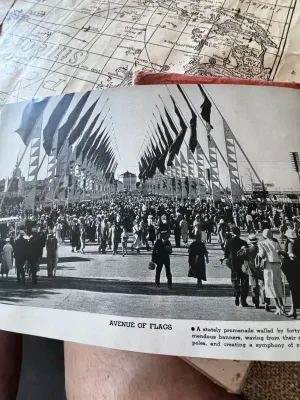 Sale Photo Thumbnail #159: An authentic 1934 souvenir book from the Chicago World's Fair, titled 'A Century of Progress'. This spiral-bound booklet features a textured pink cover with gold-embossed lettering and a central gold seal. Inside, it contains black-and-white photographic 