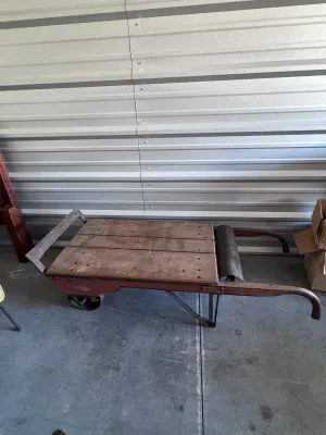 Sale Photo Thumbnail #12: An authentic antique Fairbanks wooden hand truck scale, combining a heavy-duty warehouse dolly with an integrated mechanical platform scale. Features a sturdy wood-plank bed, curved wooden handles, cast iron wheels, and the original mechanical weighing me