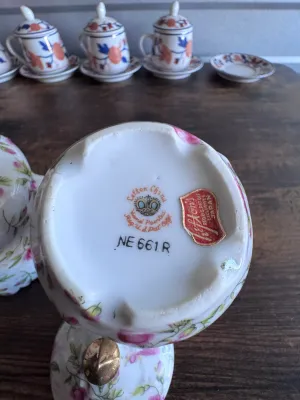 Sale Photo Thumbnail #99: A beautiful vintage 3-piece porcelain tea service set by Lefton China. This set features a delicate hand-painted pink rosebud and green leaf pattern on a white ground, accented with elegant gold-gilded trim and finials. 

Set includes:
- 1 Tall Teapot / C