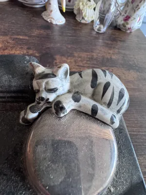 Sale Photo Thumbnail #232: A vintage novelty ceramic teapot shaped like a classic red AGA-style kitchen stove, featuring a sleeping tabby cat on top alongside a kettle and pot details. Marked on the underside 'Swineside Ceramics England'. Condition shows overall crazing to the glaz