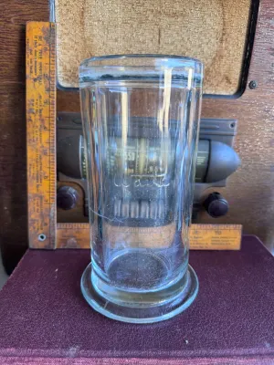 Sale Photo Thumbnail #290: A vintage clear glass battery jar manufactured by Whitall Tatum Co. in Millville, New Jersey. The jar features the embossed script "Whitall" on the front side and is embossed on the bottom rim with "WHITALL TATUM CO. MILLVILLE N.J. U.S.A.". It stands appr