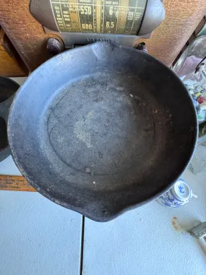 Sale Photo Thumbnail #277: A vintage cast iron skillet featuring the distinctive teardrop-shaped handle hole and number marking characteristic of the Chicago Hardware Foundry (CHF), made in North Chicago, Illinois. The bottom shows a raised number '4' and a diamond mark. The skille