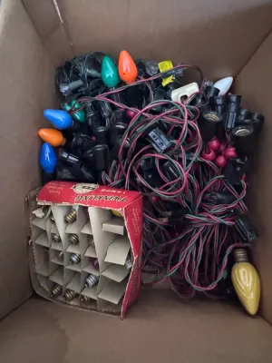 Sale Photo Thumbnail #109: A large estate collection of vintage Christmas lighting. Includes multiple green and red/pink insulated wire light strings with black sockets, a vintage red cardboard box of 'Twinkling Lamps' by World Wide, and a large assortment of loose ceramic and pain